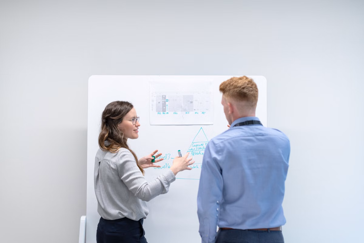 Engineer presenting technical work at a whiteboard