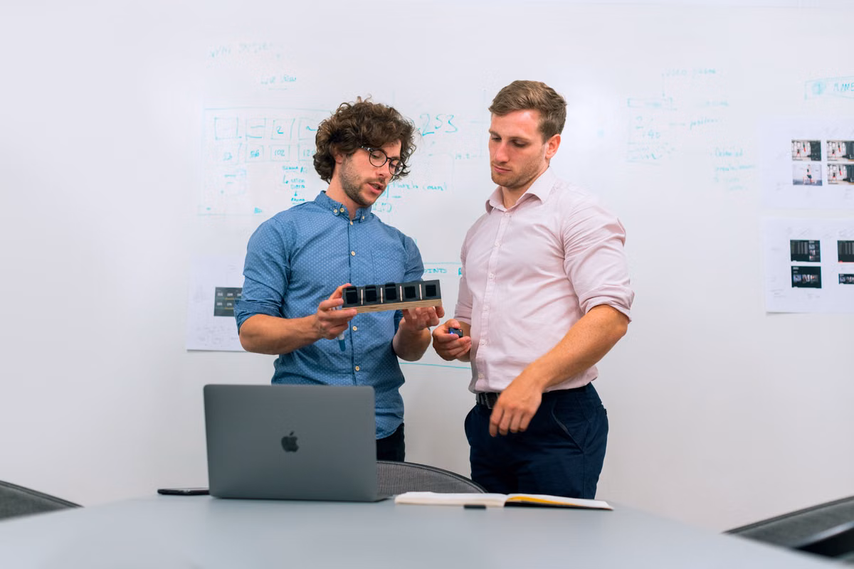 Two engineers reviewing a technical prototype together