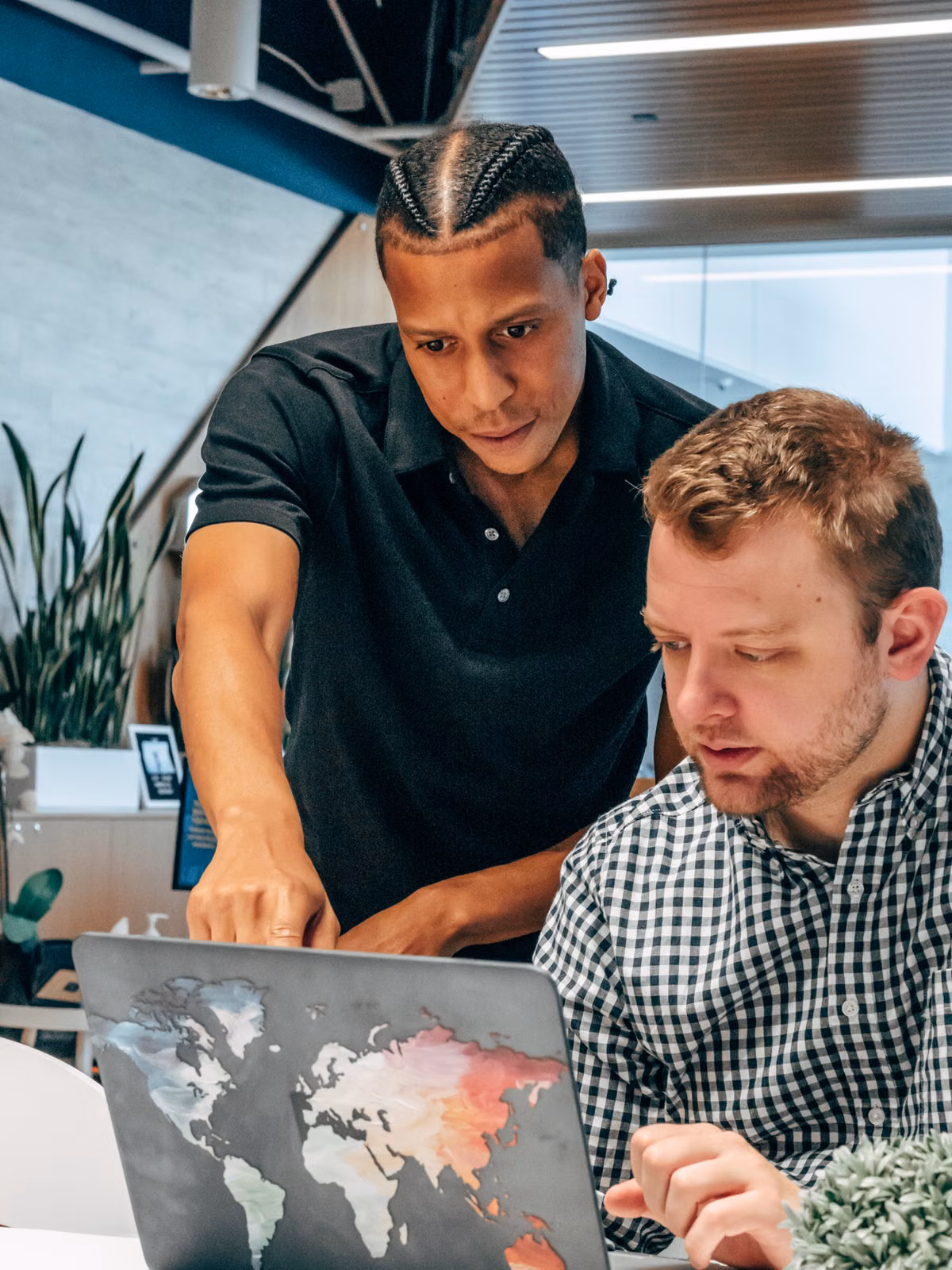 Two colleagues collaborating over a laptop